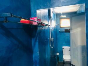 a blue bathroom with a toilet and a blue wall at Dinesh House in Weligama +27 photos