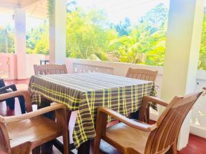 a dining room with a table and chairs and a window at Dinesh House in Weligama