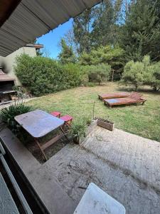 a picnic table and a bench in a yard at La Rosadita in Necochea +1 photo