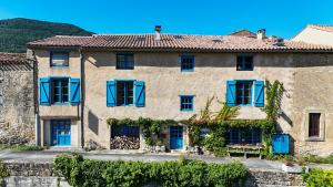 an old stone house with blue shutters at Le Presbytère de Bugarach in Bugarach