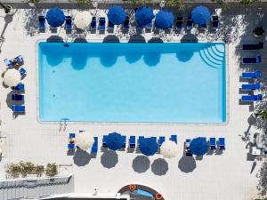 an overhead view of a swimming pool with blue umbrellas at Hotel Caravelle - Nuova Gestione 2026 in Cattolica