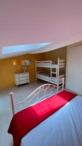 a bedroom with two bunk beds with a red blanket at Country home in Riocaud +12 photos