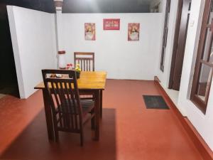 a dining room with a wooden table and chairs at Lotus Ella Homestay in Badulla