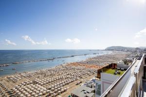 a view of a beach with umbrellas and the ocean at Hotel Caravelle - Nuova Gestione 2026 in Cattolica