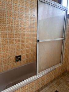 een douche met een glazen deur in een badkamer bij Linda in Mar del Plata +4 foto's