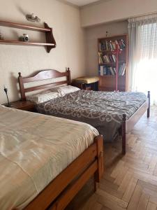 een slaapkamer met 2 bedden en een boekenplank bij Linda in Mar del Plata