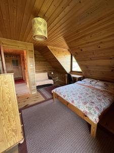 een slaapkamer met een bed in een houten hut bij Malina in Zawóz