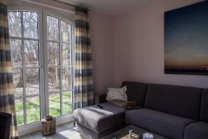 a living room with a couch and a large window at Haus Meeresblick Ferienwohnung Kra in Baabe