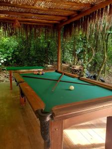 a pool table with a pool ball on top of it at Pousada AimeMaresias - Casa 2 quartos na mata -01 in São Sebastião