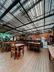 a large room with wooden tables and wooden chairs at Pousada AimeMaresias - Casa 2 quartos na mata -01 in São Sebastião