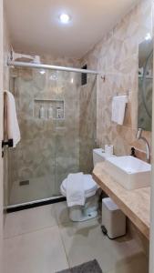 a bathroom with a shower and a toilet and a sink at Hotel Brasil T Sensacional PREMIUM in Fortaleza