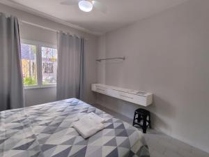 una camera da letto con un letto, un comò e una finestra di Casa 215 Suítes pertinho da Praia a Balneário Camboriú Altre 22 foto