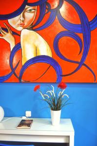 a painting of a woman on a wall next to a table at Sevillarent in Seville