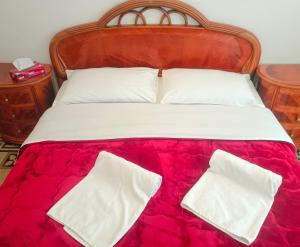 a bed with white pillows and a red blanket at Fatima House in Rome +7 photos
