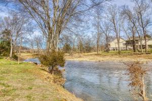a river with a house in the background at River Cabin in Pigeon Forge