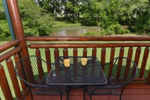 two chairs and a table on a porch with two coffee cups at River Cabin in Pigeon Forge +22 photos
