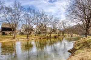 a river with trees and buildings in the background at River Cabin in Pigeon Forge