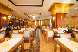 a dining room with wooden tables and chairs at Throne Beach Resort & Spa - Ultra All Inclusive in Manavgat