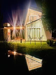 Finca La Escondida San Rafael في سان رافاييل: منزل مع انعكاس في الماء في الليل