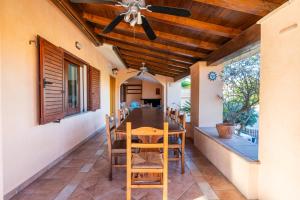 a dining room with a ceiling fan and a table and chairs at Villa Sa Marina con piscina in Bari Sardo