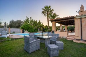 a patio with chairs and a table and a pool at Villa Sa Marina con piscina in Bari Sardo