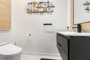 une salle de bains avec toilettes et lavabo dans l'établissement Luxury 5BR Smart Home Near JFK with Gym, Theater & BBQ, à Valley Stream 56 autres photos