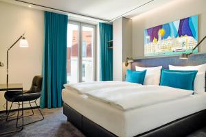 ein Hotelzimmer mit einem großen Bett und einem Schreibtisch in der Unterkunft Motel One Ulm in Ulm