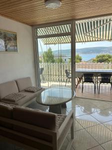 een woonkamer met een bank en een glazen tafel bij Manda & Marko Jurić in Seline