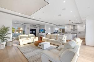 Il comprend un salon avec un mobilier blanc et une cuisine. dans l'établissement Luxury 5BR Smart Home Near JFK with Gym, Theater & BBQ, à Valley Stream