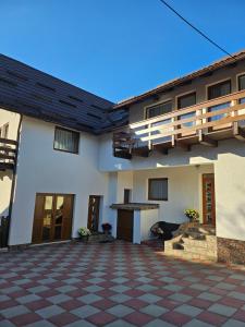 a large white building with a checkered floor at Alio Guest House in Zărneşti