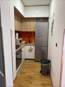 a kitchen with a stainless steel refrigerator and wooden cabinets at Sarajevo Bulevar in Sarajevo