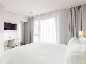 Voodi või voodid majutusasutuse Nonanteneuf appart hōtel Vevey - contactless check-in toas