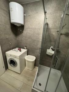 a bathroom with a shower and a washing machine at Sarajevo Bulevar in Sarajevo +6 photos