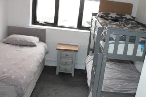 a bedroom with two bunk beds and a night stand at Beach View, Portballintrae in Portballintrae