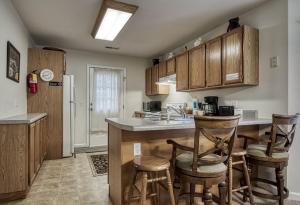 a kitchen with wooden cabinets and bar stools at Henderson's Riverside in Pigeon Forge