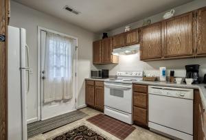 a kitchen with white appliances and wooden cabinets at Henderson's Riverside in Pigeon Forge