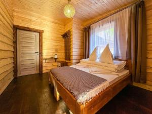 BerezhnytsyaにあるГотель ЙомоЙоの木製の部屋にベッド1台が備わるベッドルーム1室があります。