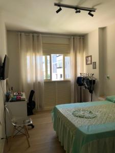 萨尔瓦多Apartamento - Salvador的一间卧室，里面有一张床、一张桌子和一扇窗户