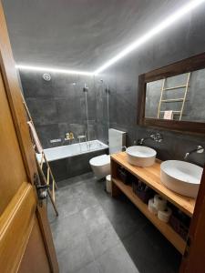 a bathroom with two sinks and a toilet and a tub at Appartement Le Zenith à Verbier in Verbier