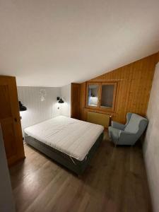 a bedroom with a bed and a chair in it at Appartement Le Zenith à Verbier in Verbier