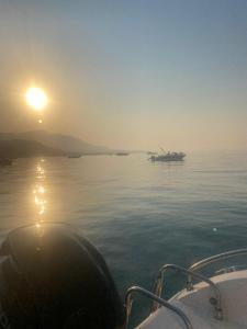 een boot in het water met de zon in de lucht bij Casa Julia in Palermo +5 foto's