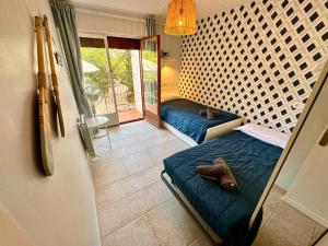 a room with two beds in a room with a mirror at Apartament al Golfet de Calella de Palafrugell in Calella de Palafrugell