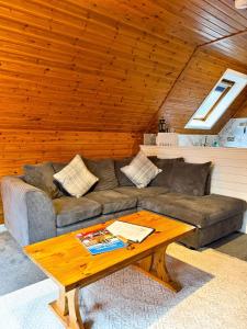 a living room with a couch and a coffee table at Macha 3 - Hot Tub-Perth-Pets-Family-Luxury-Cabin in Perth