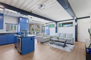 Una cocina y sala de estar con gabinetes azules y una mesa. en Stadium Container Club House, en Indianápolis