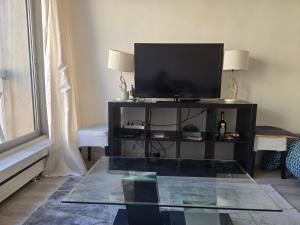 sala de estar con TV y mesa de cristal en Cosy Studio Close Eiffel Tower, en París