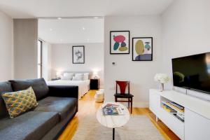 a living room with a couch and a bed at The Borough Collection near London Bridge and Borough Market - by Short Stories London in London