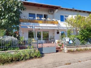 a white house with a fence in front of it at Sirokkó Apartman in Balatonfüred