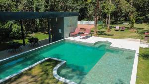 a swimming pool with blue water in a yard at Ecolounge Studios in Pirenópolis