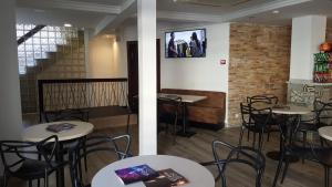 un restaurante con mesas y sillas blancas y una pared de ladrillo en Hotel Queens - Adults Only, en Benidorm