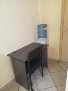 a black desk with a chair in a room at Hadassah apartment in Nairobi